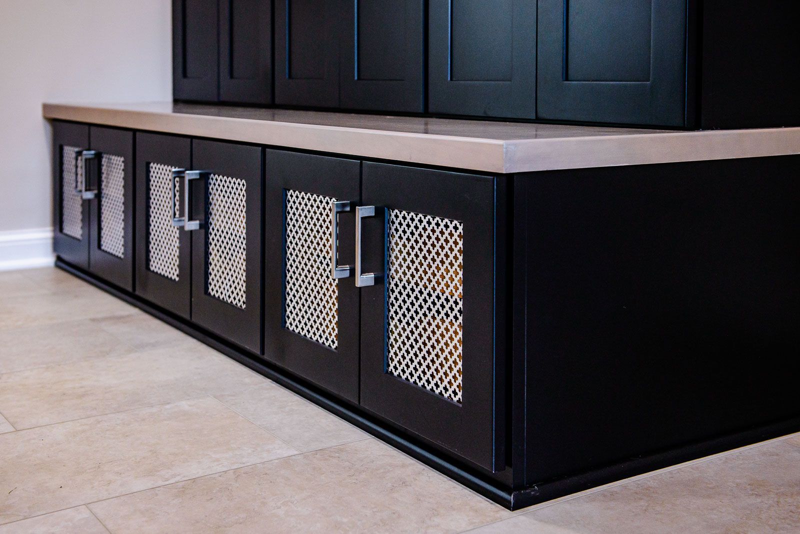 A row of black cabinets with mesh doors