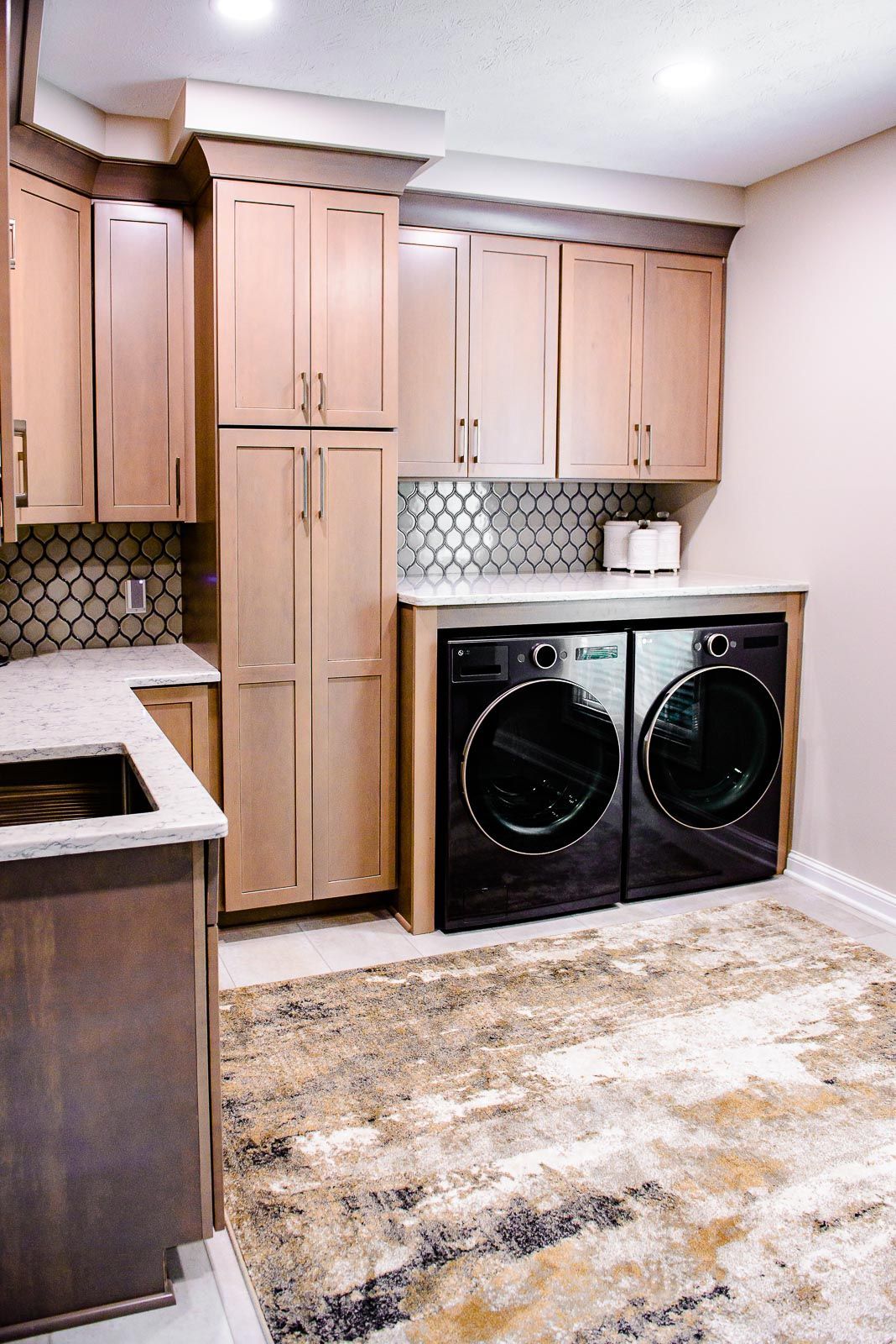 A laundry room with a washer and dryer and a sink.