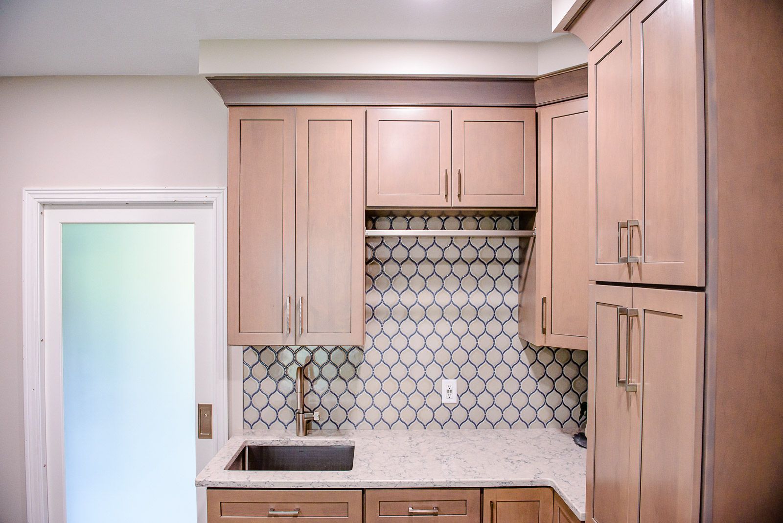 A kitchen with wooden cabinets , granite counter tops , and a sink.