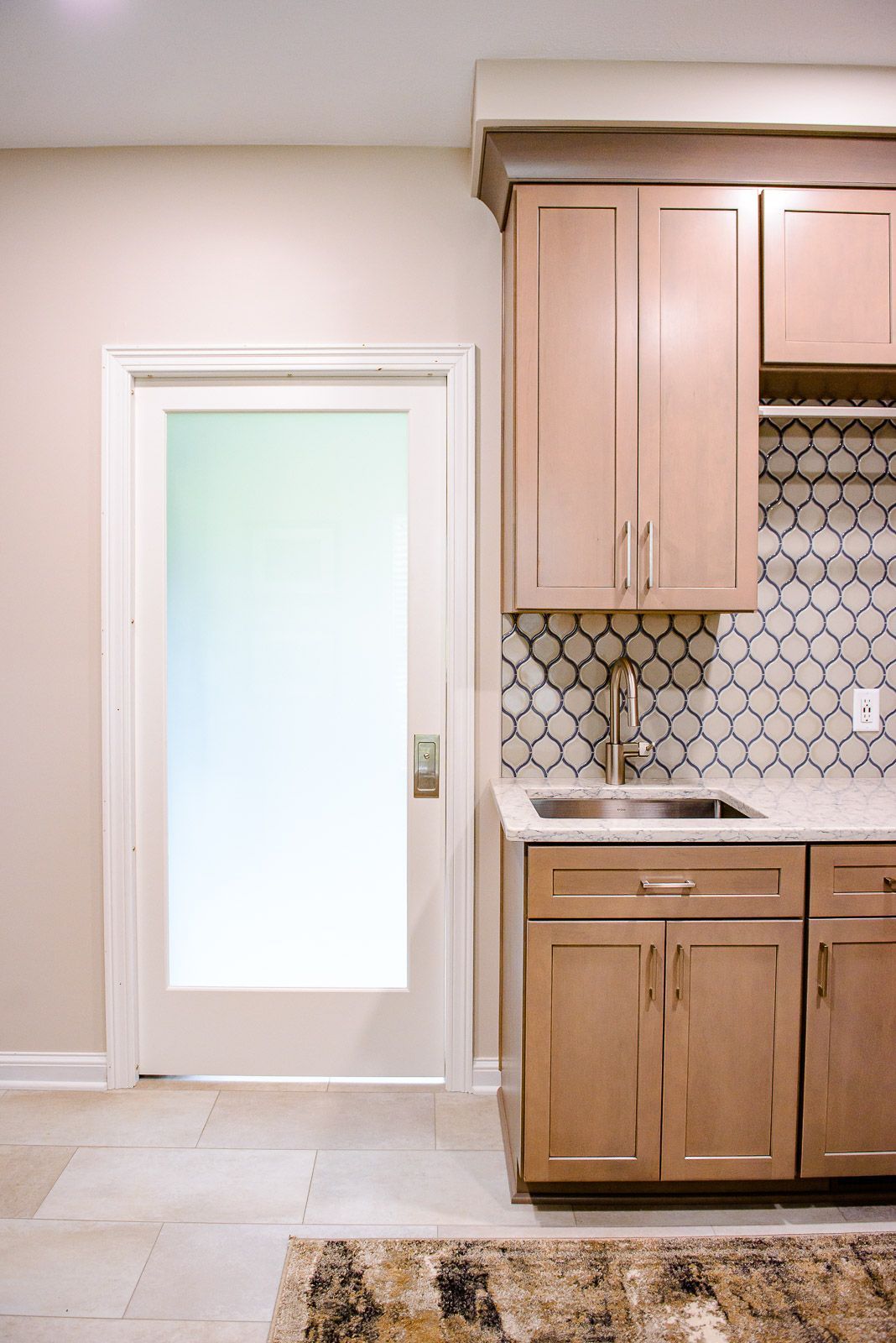 A kitchen with a sink , cabinets , and a door.