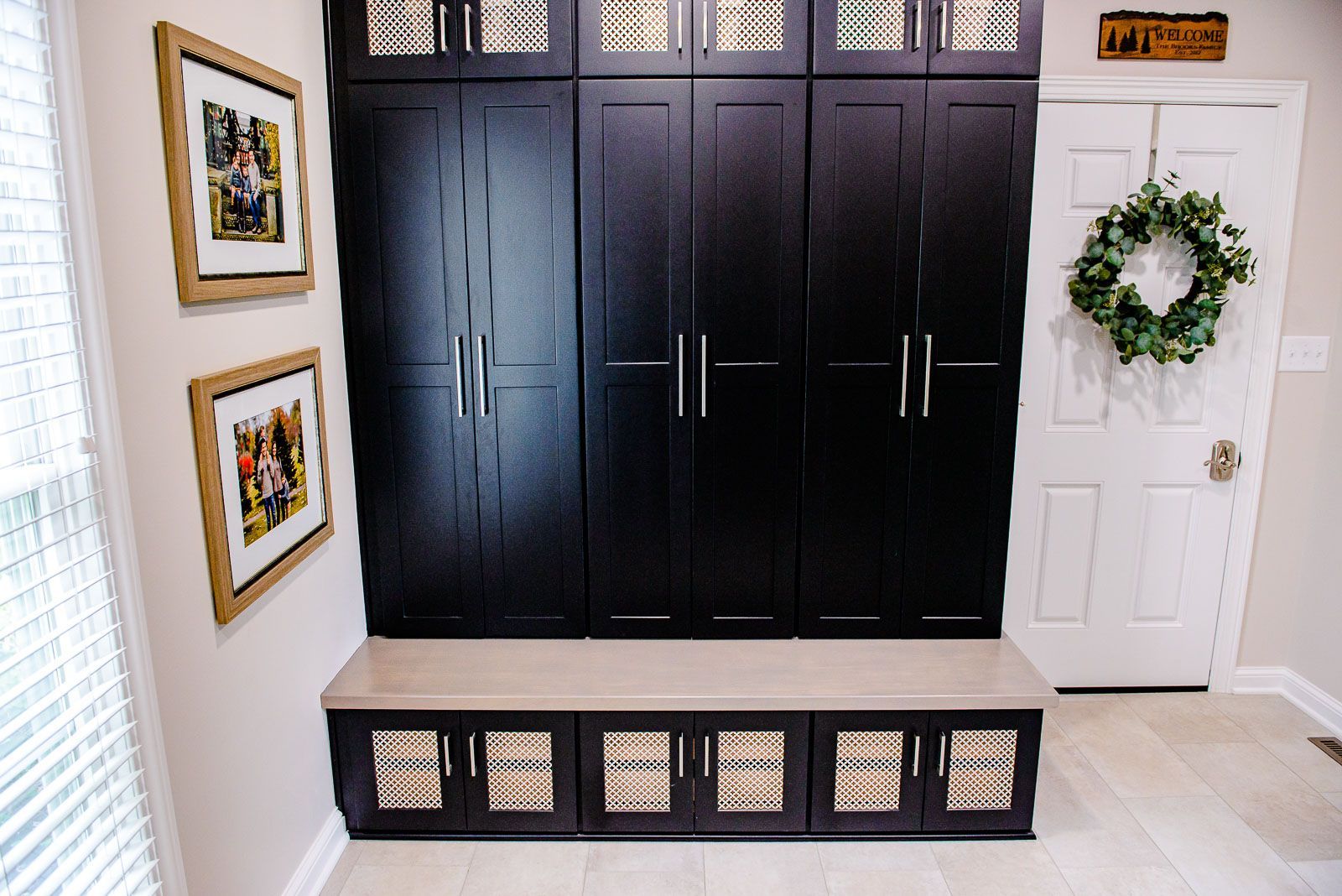 A hallway with black cabinets and a wreath on the door.