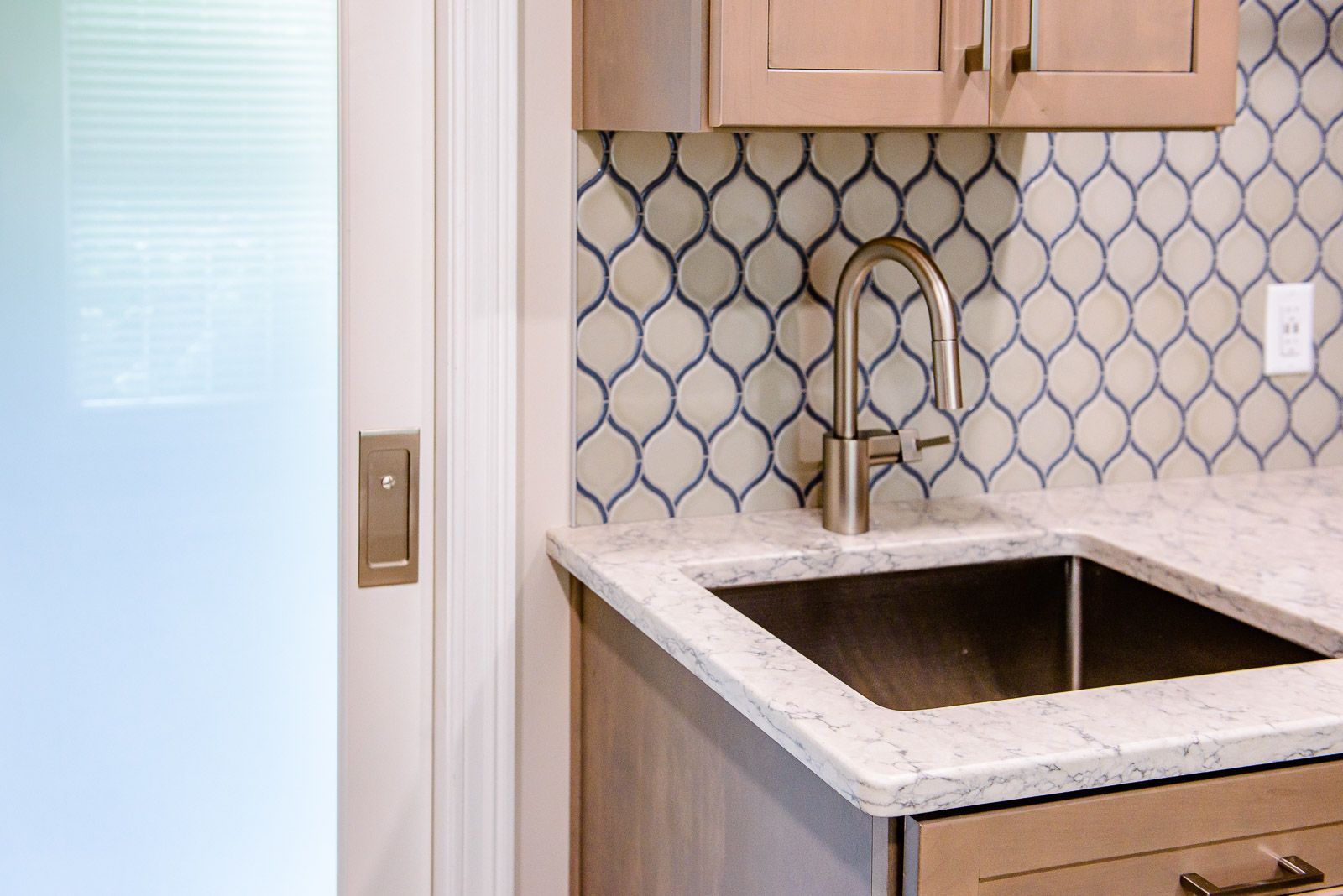 A kitchen with a sink , faucet and cabinets.