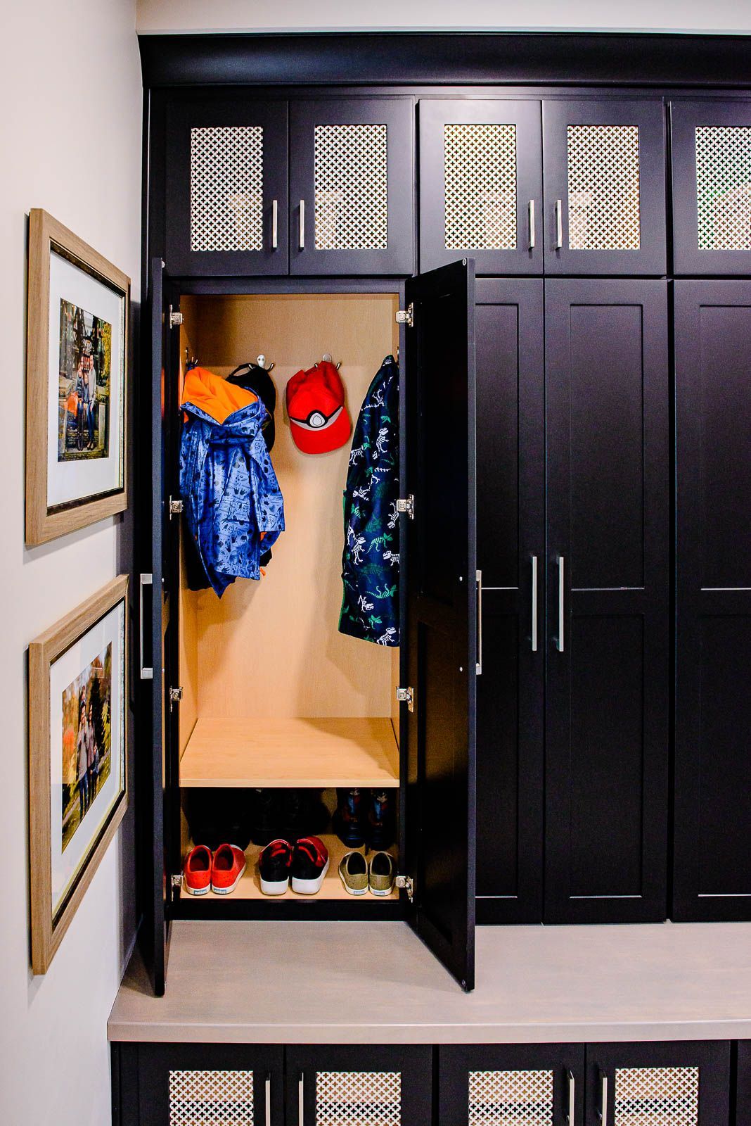 A closet with the doors open and clothes and shoes inside