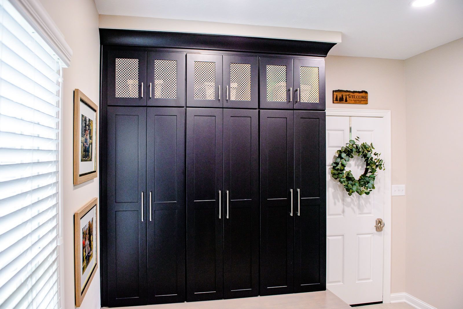 A room with black cabinets and a wreath on the door