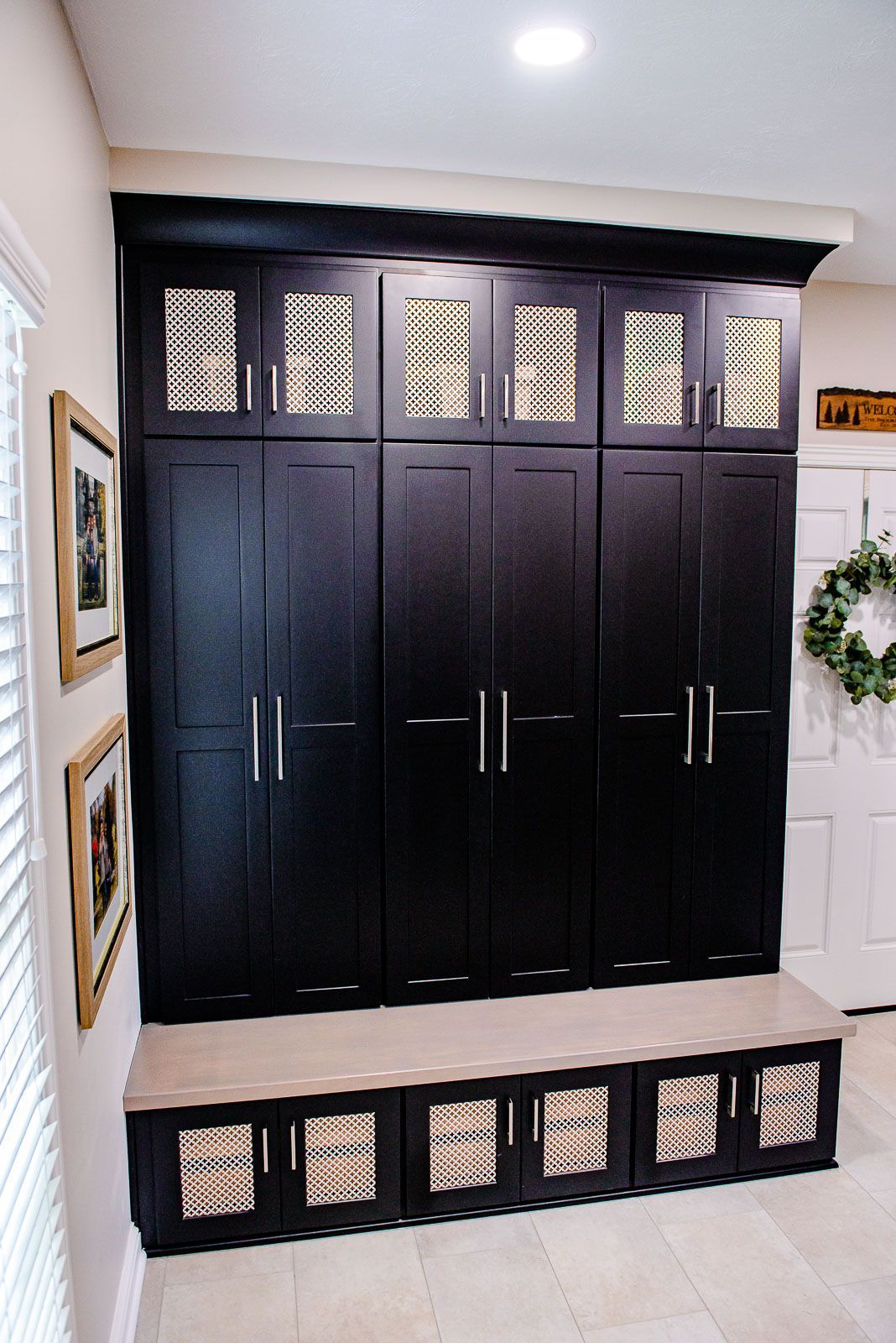 A closet with a bench and a wreath on the wall
