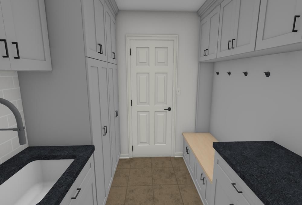 A laundry room with a sink , cabinets , and a bench.