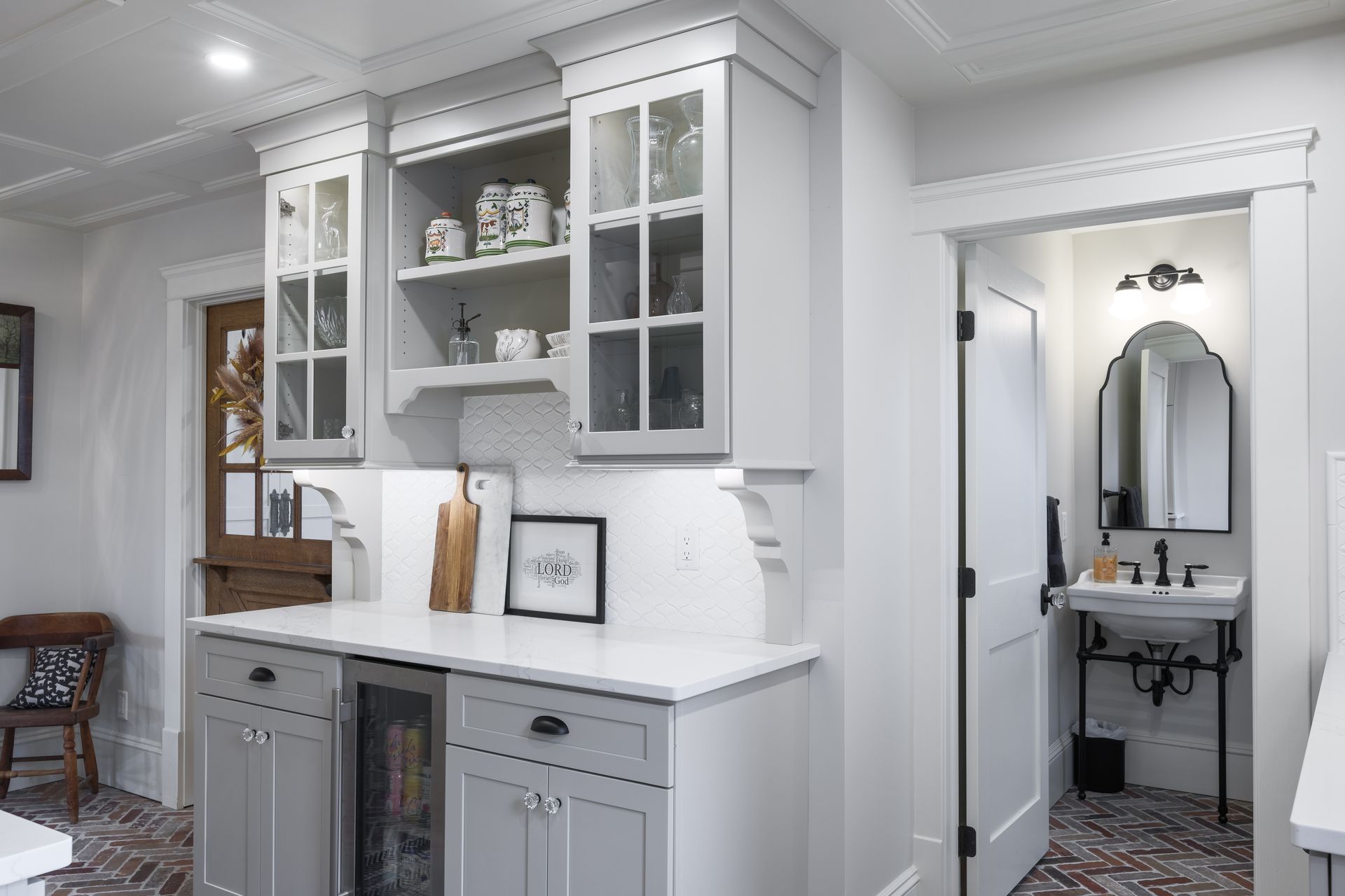 Gray kitchen with cabinets, countertops, and a wine fridge. A doorway leads to a powder room.