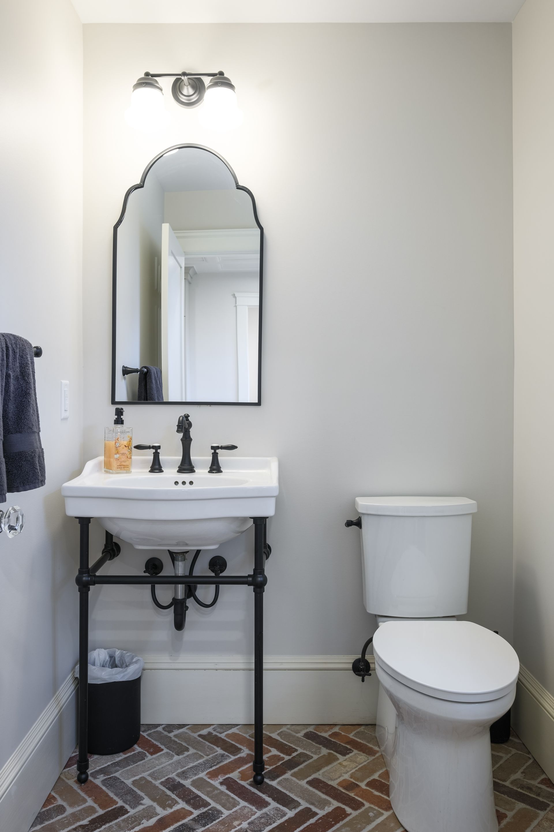 A bathroom with a sink , toilet and mirror.