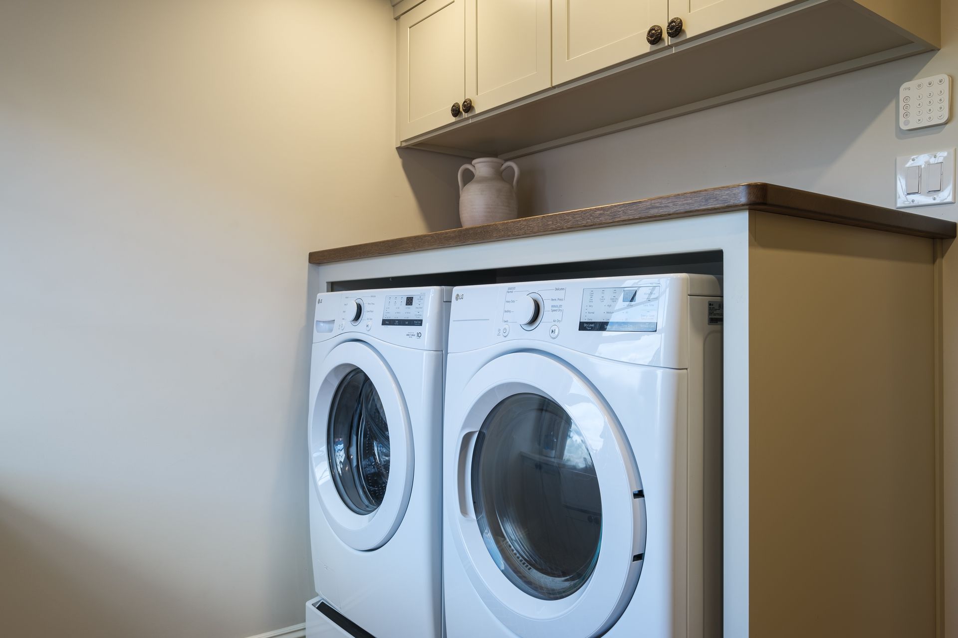 A laundry room with two washing machines and a dryer.