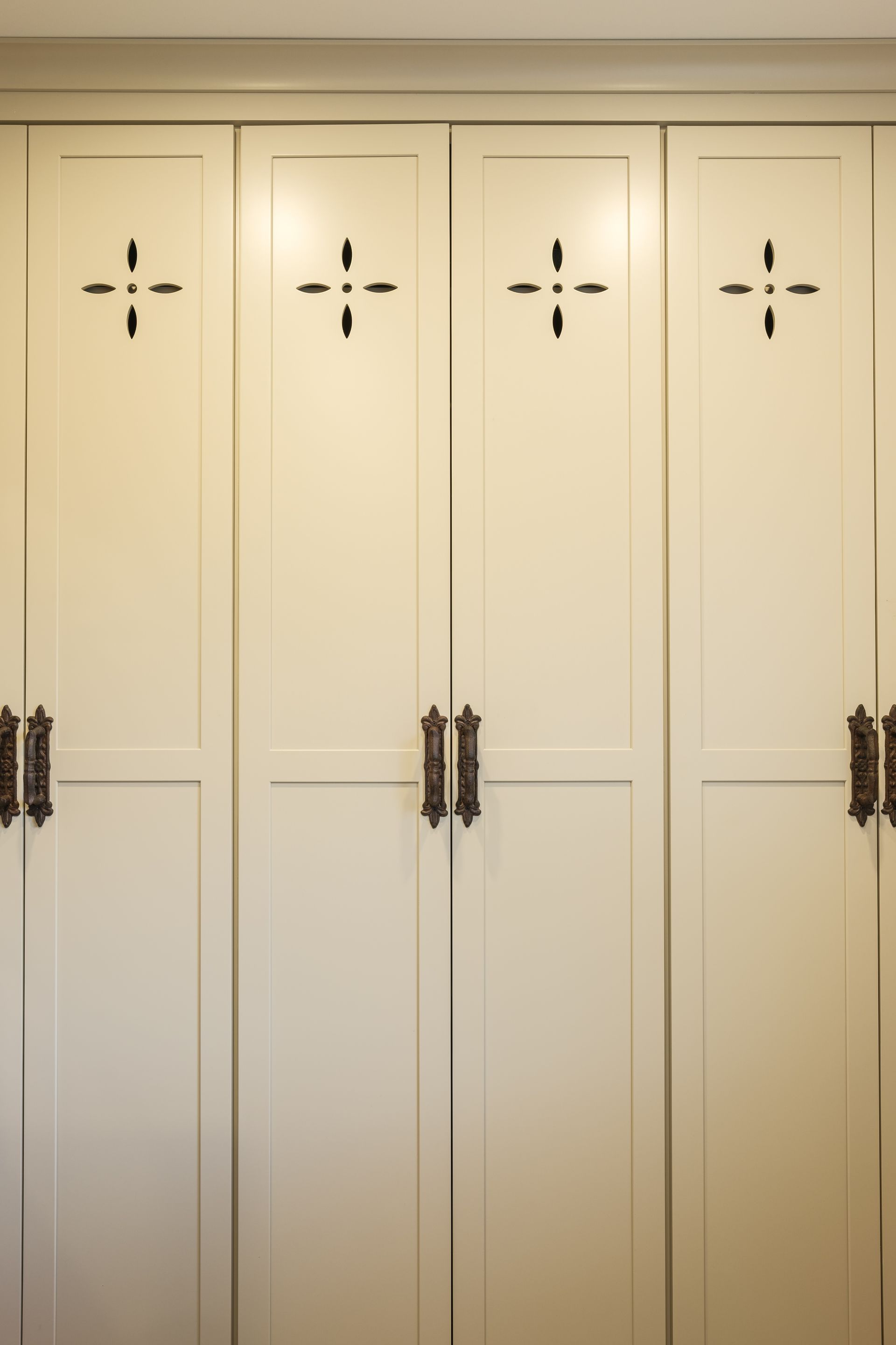A row of white cabinets with crosses on the doors