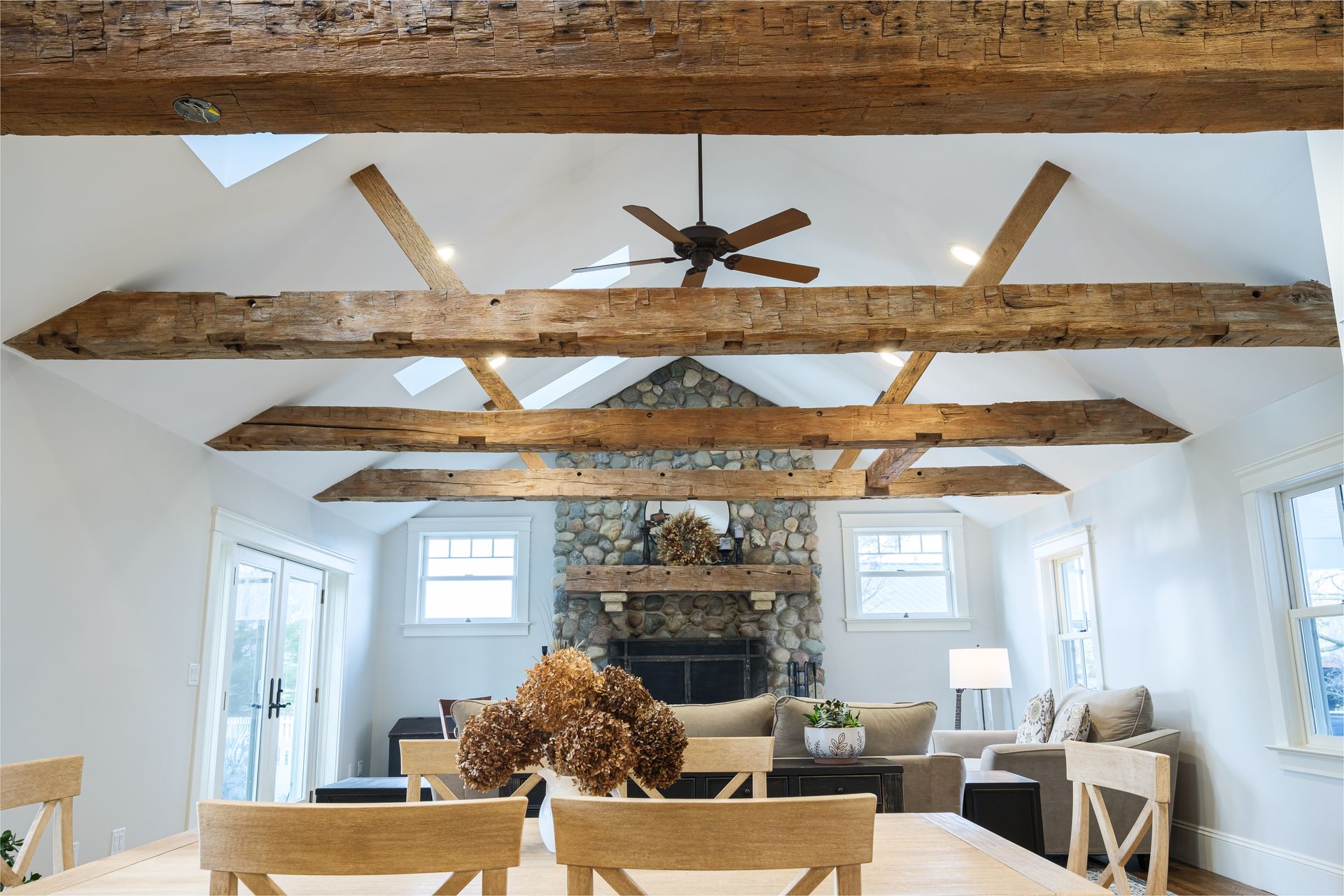A living room with wooden beams and a ceiling fan