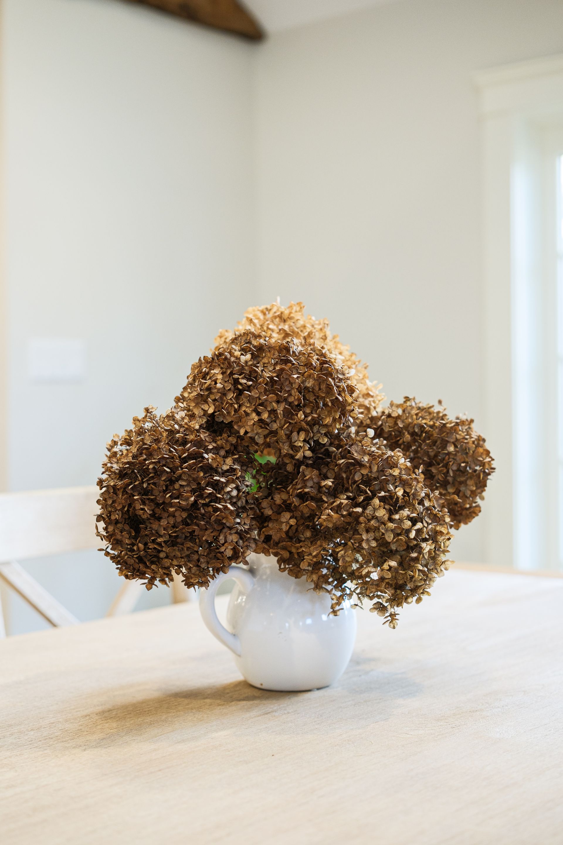A vase filled with dried flowers is sitting on a table.