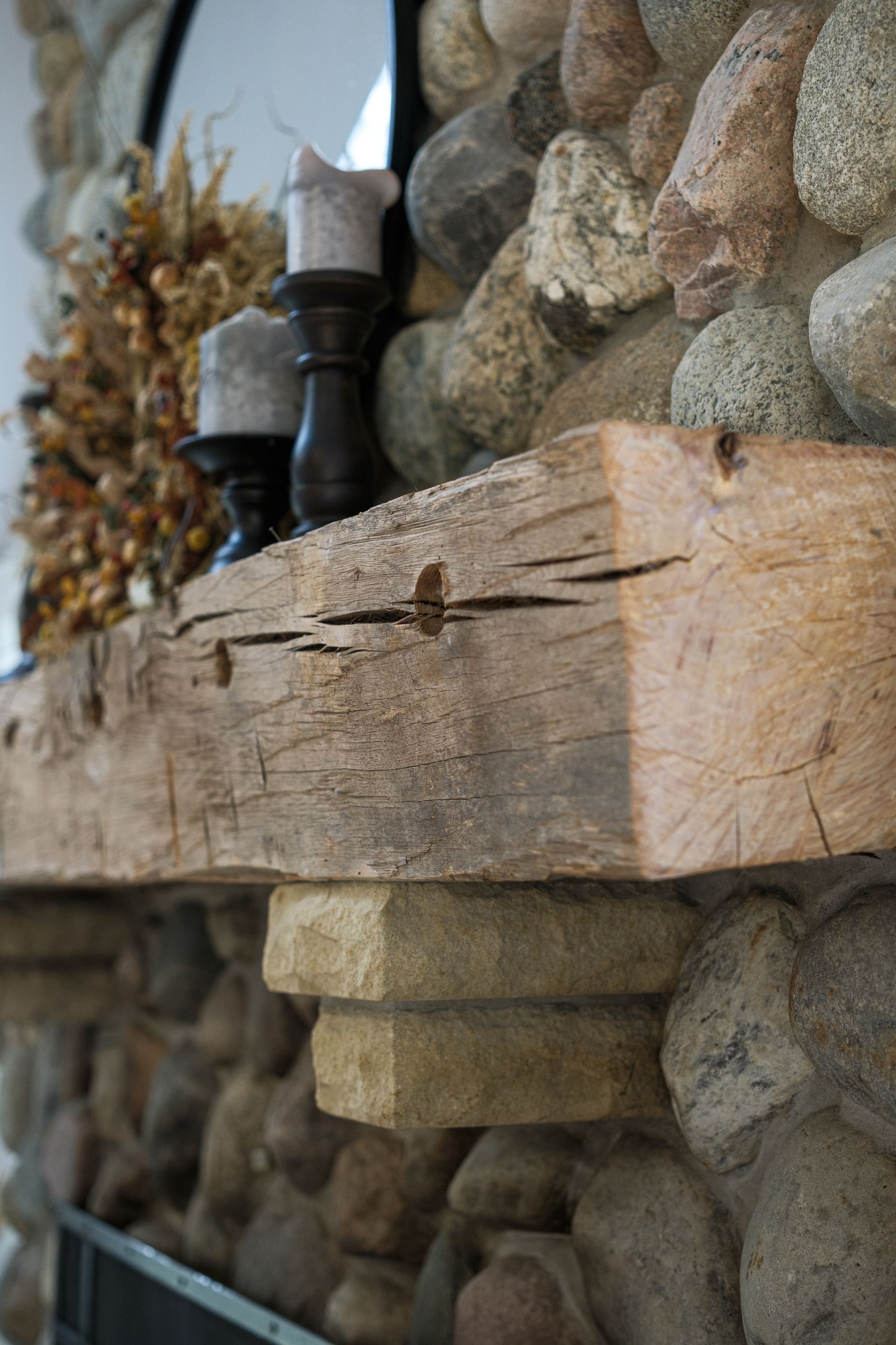 A wooden mantle is sitting on top of a stone fireplace.