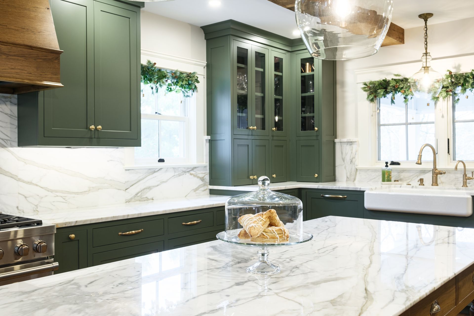 A kitchen with green cabinets and white counter tops