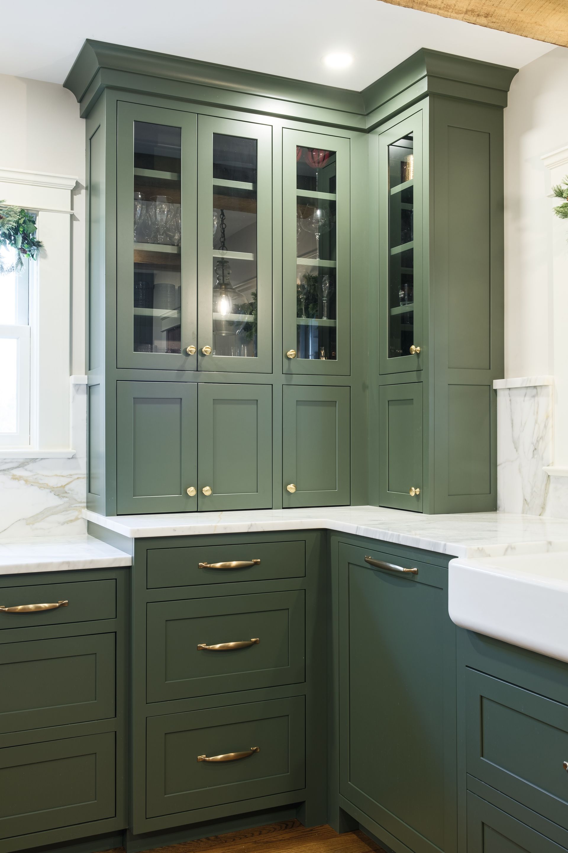A kitchen with green cabinets and a white sink.