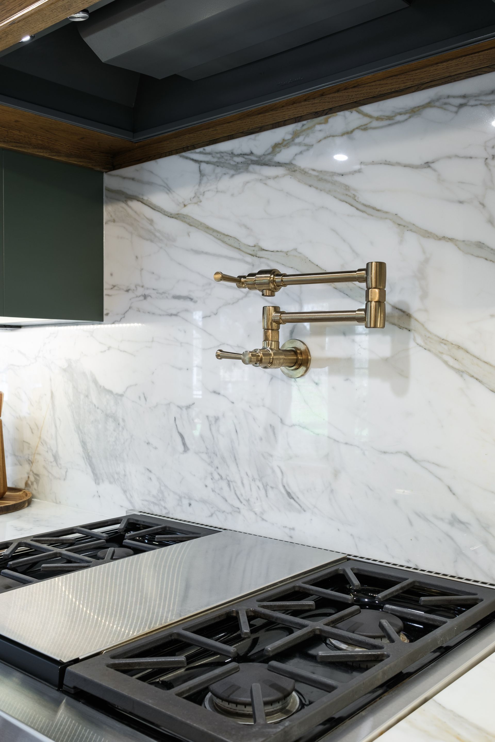 A kitchen with a stove top oven and a faucet on the wall.