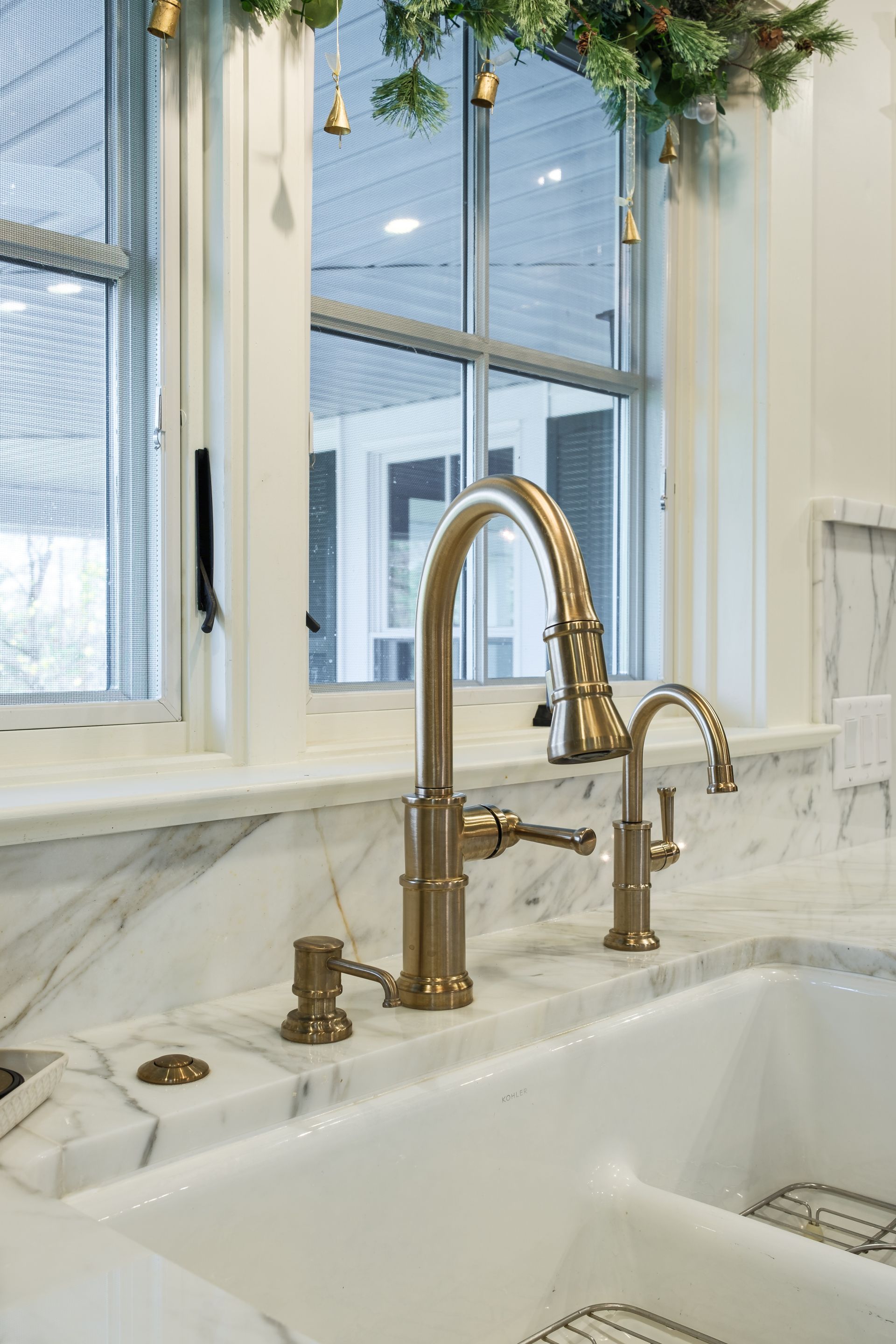 A kitchen sink with a faucet and a window.