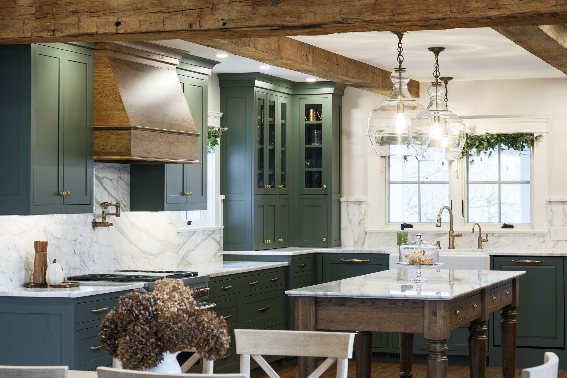 A kitchen with green cabinets and a wooden table
