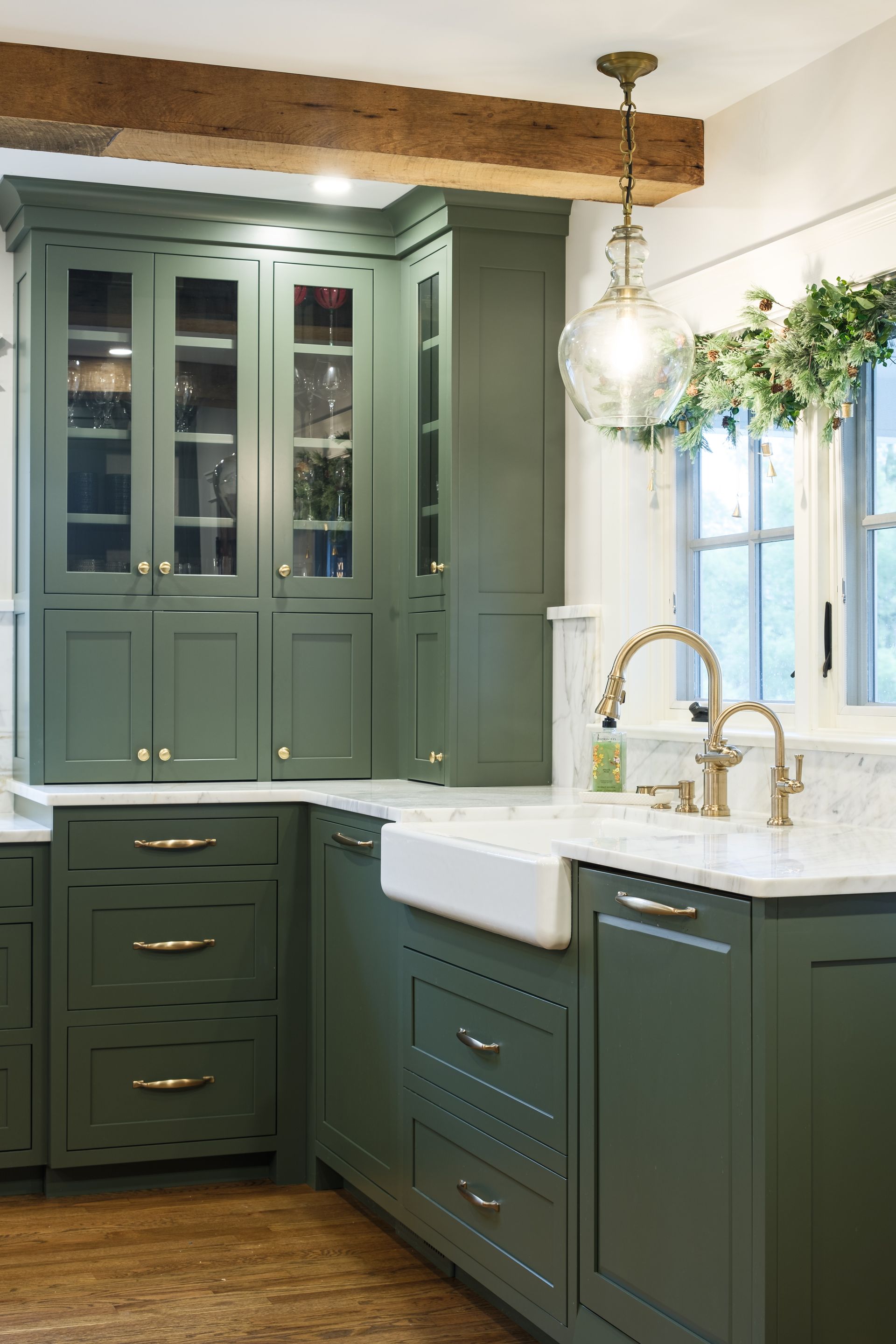 A kitchen with green cabinets and a white sink.