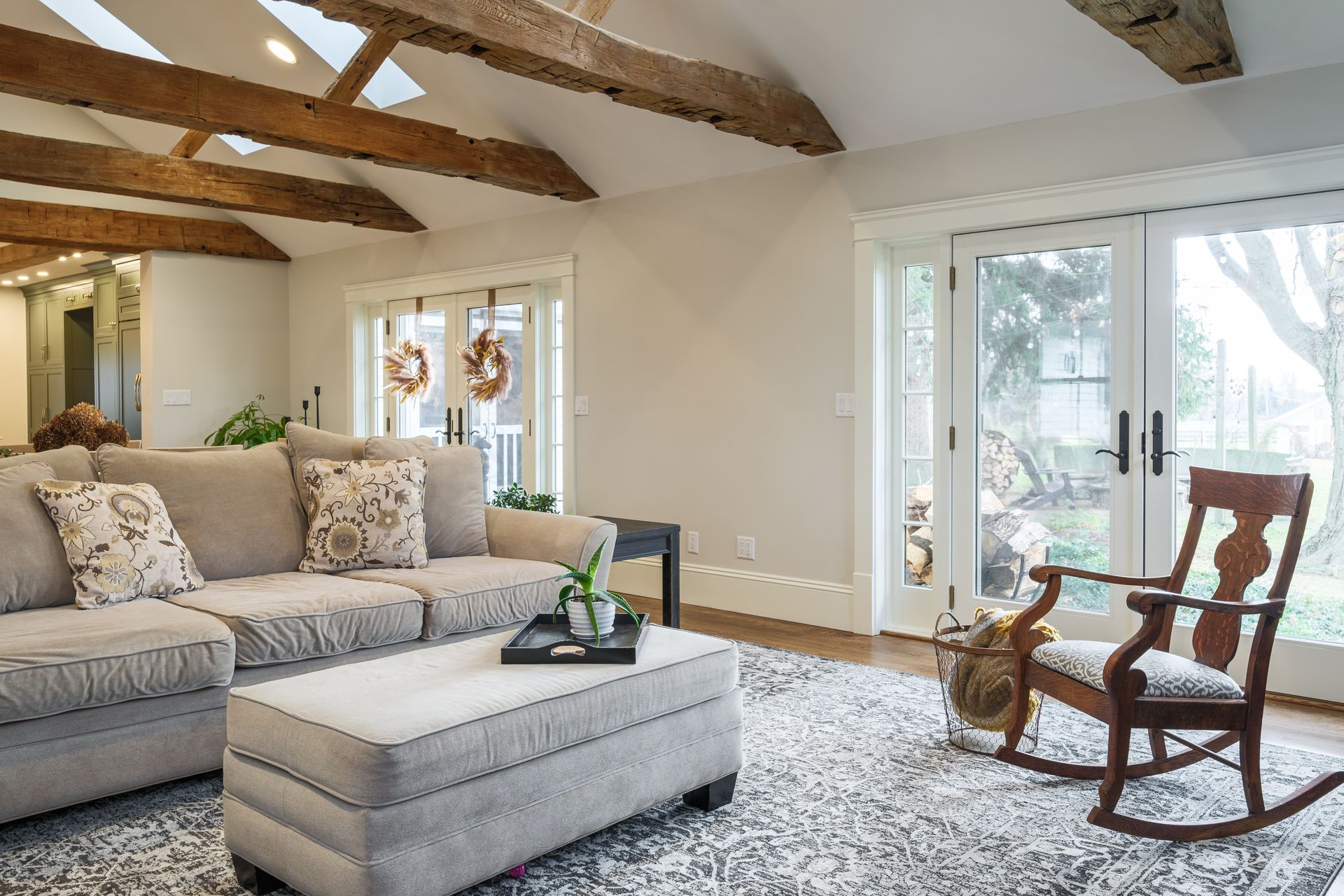 A living room with a couch , rocking chair , coffee table and ottoman.