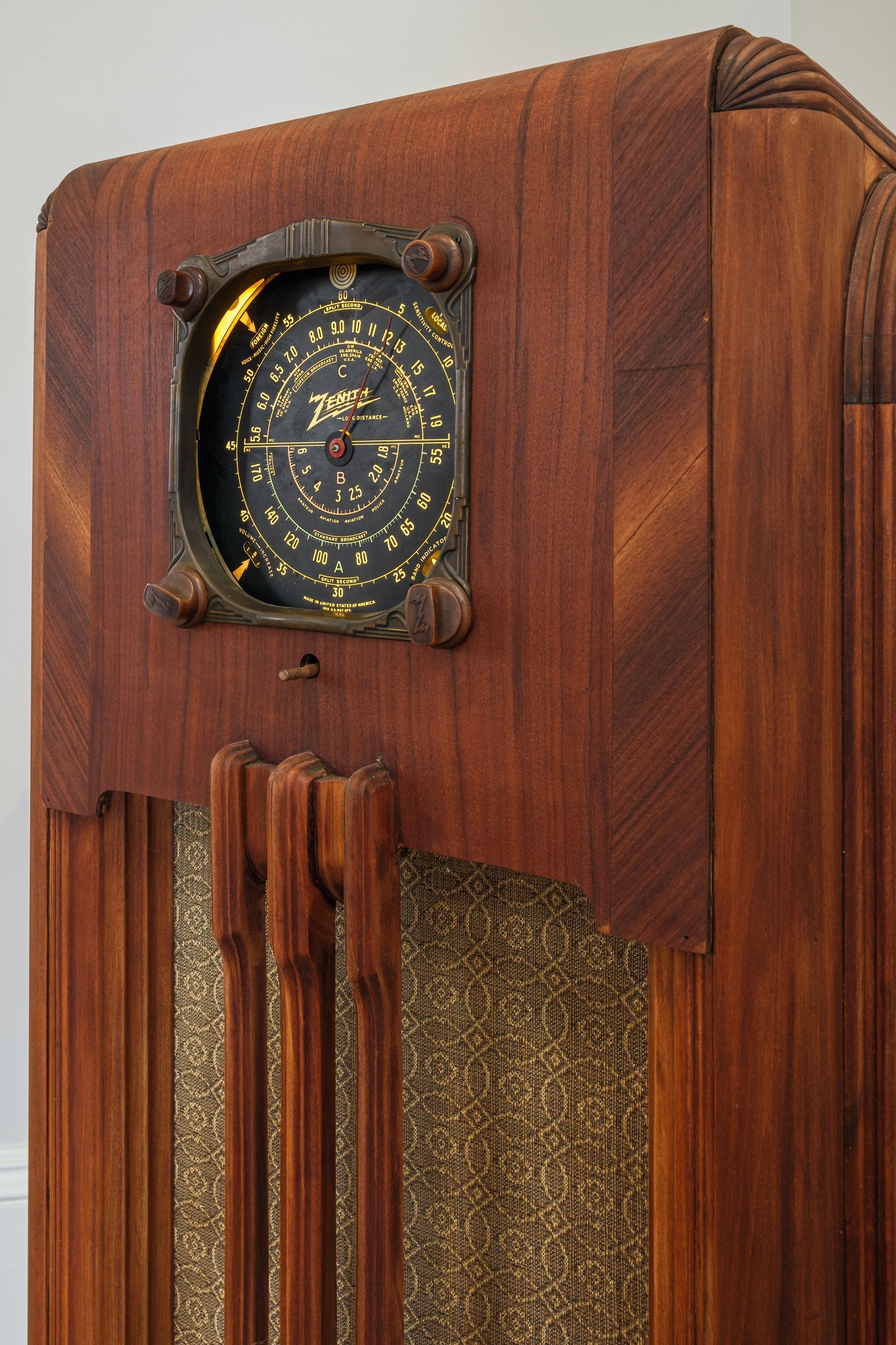 A wooden radio with a clock on top of it