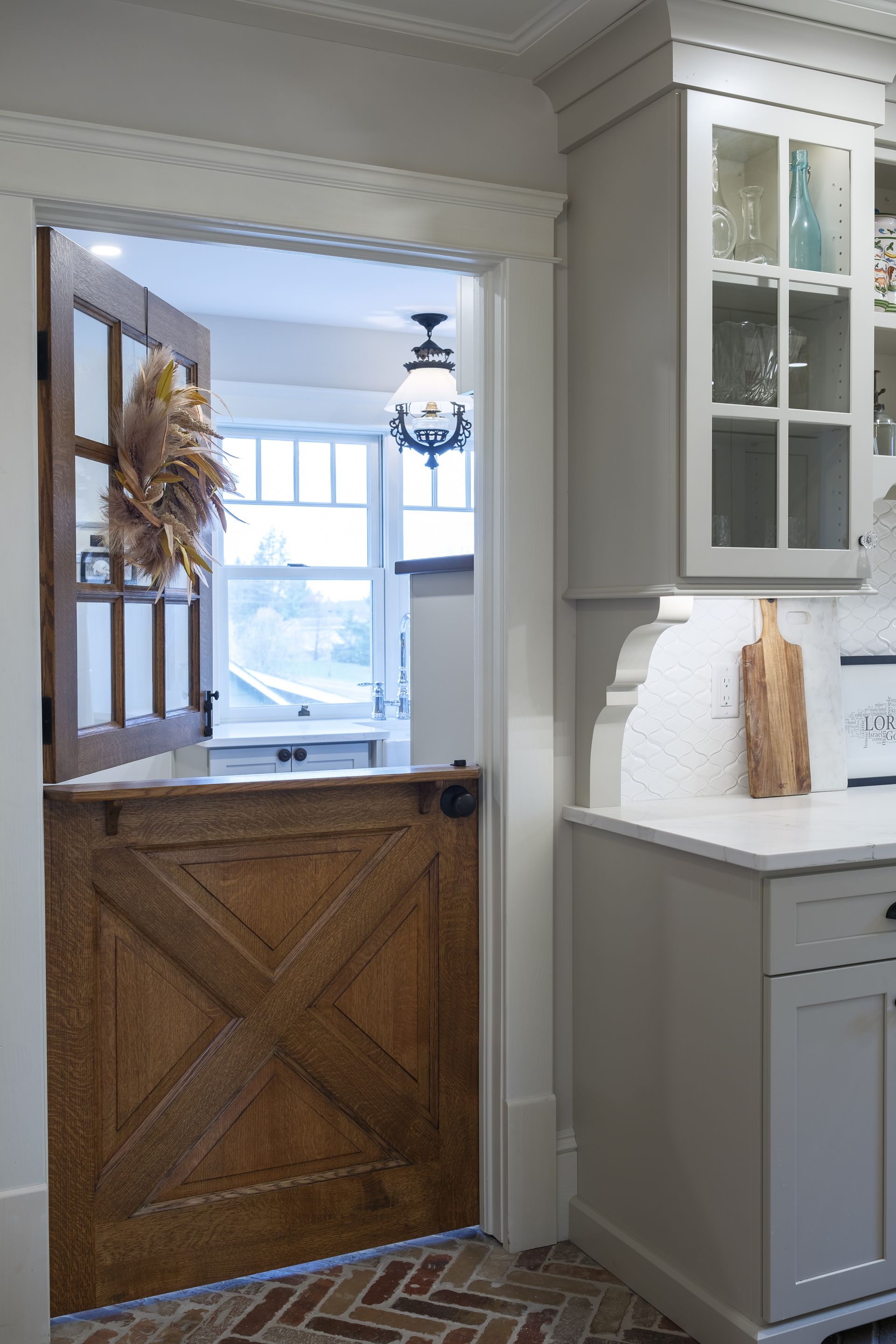 A kitchen with a wooden door and white cabinets