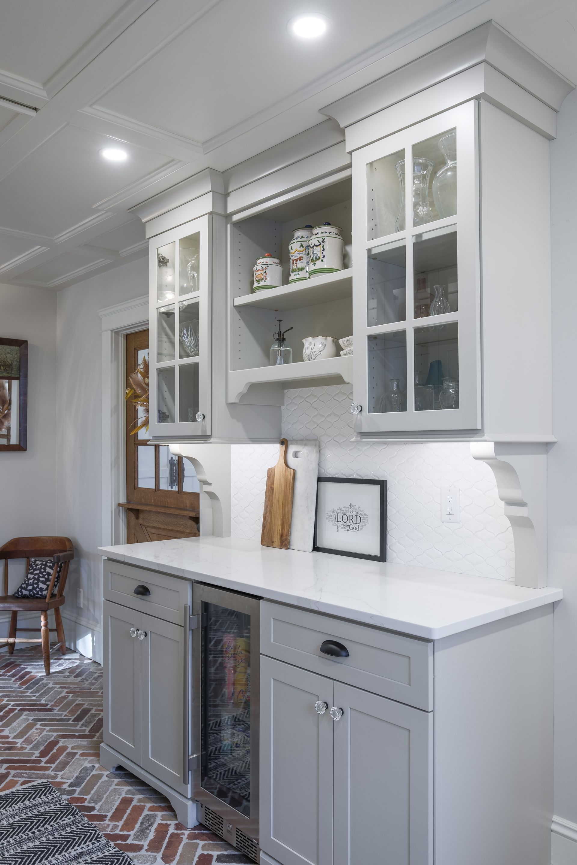 A kitchen with white cabinets and a stainless steel refrigerator.