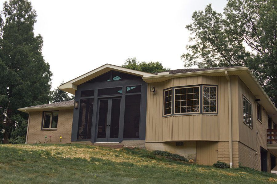 A house with a screened in porch and lots of windows