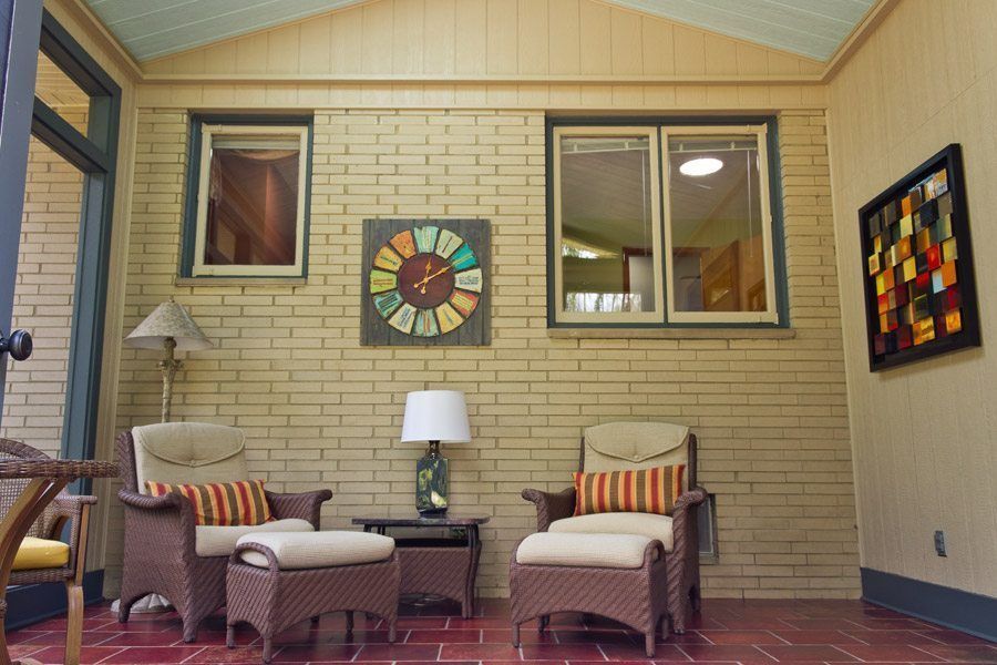 A living room with wicker furniture and a clock on the wall