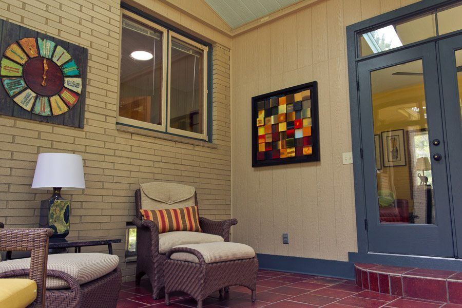 A living room with a chair and ottoman and a clock on the wall