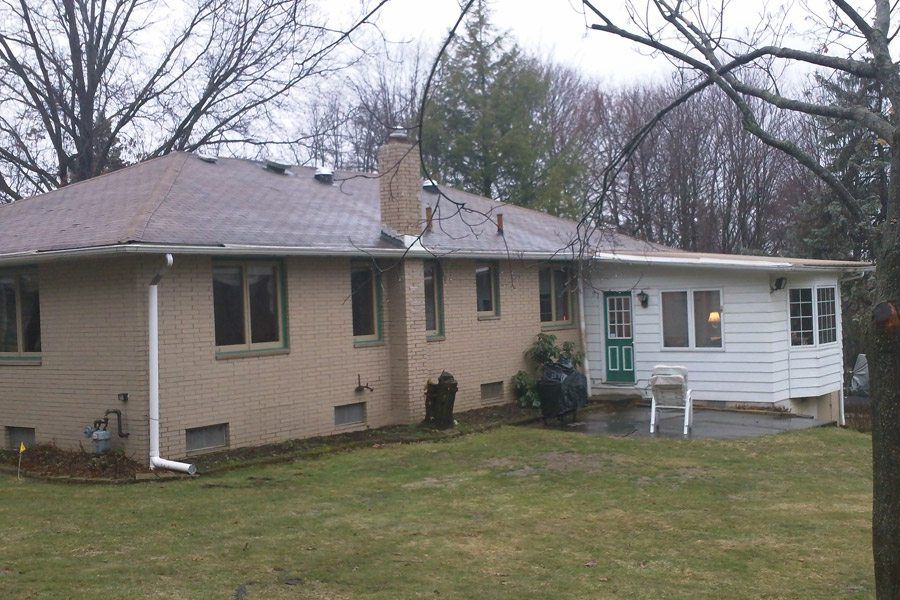 A brick house with a white trim and a green door