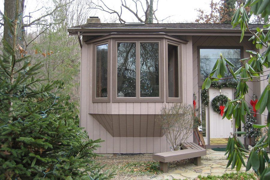 A house with a large window and a bench in front of it