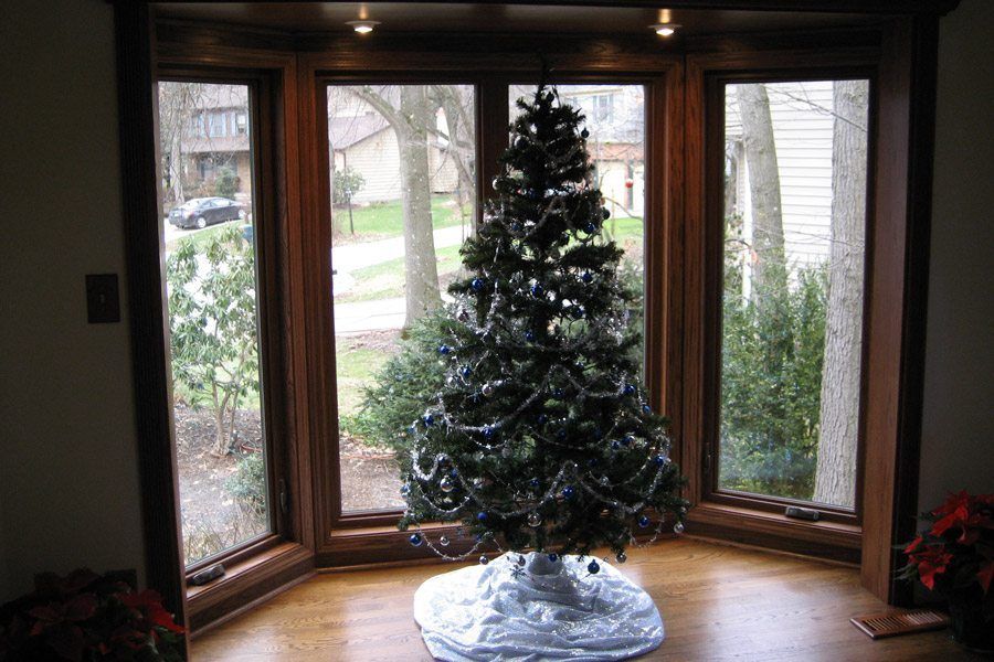 A christmas tree is sitting in a bay window