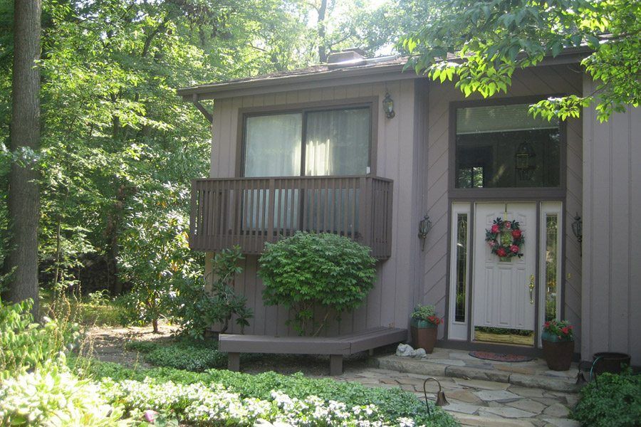 A small house with a balcony and a wreath on the door