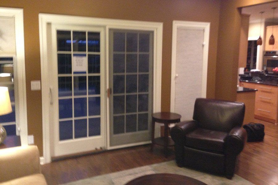 A living room with a brown chair and a sliding glass door