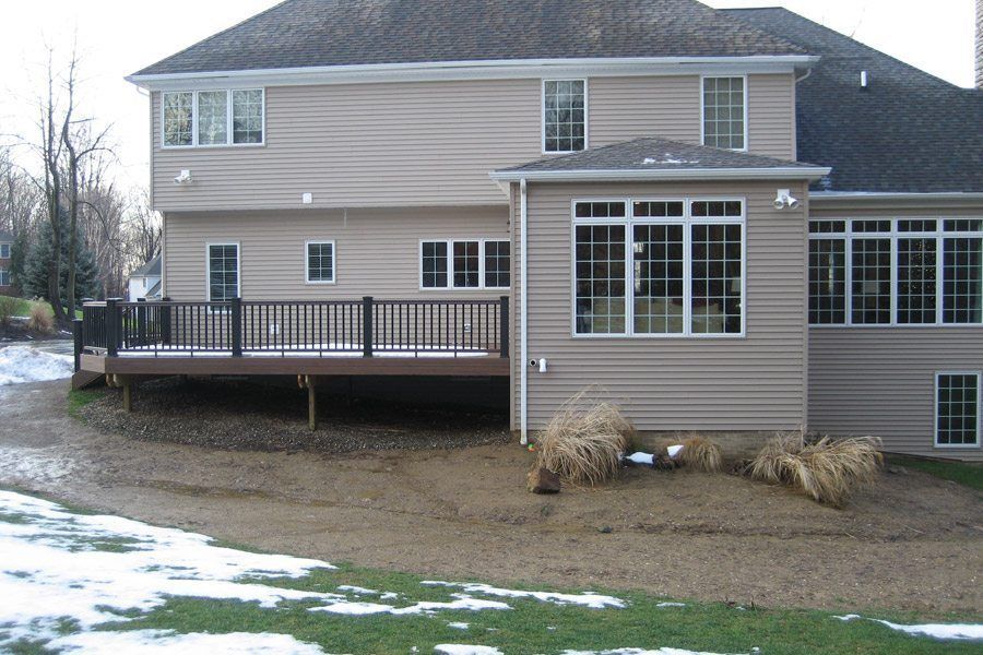 A large house with a large deck and lots of windows