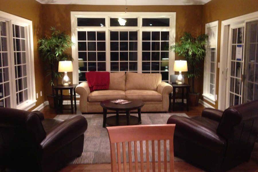 A living room with a couch two chairs and a table