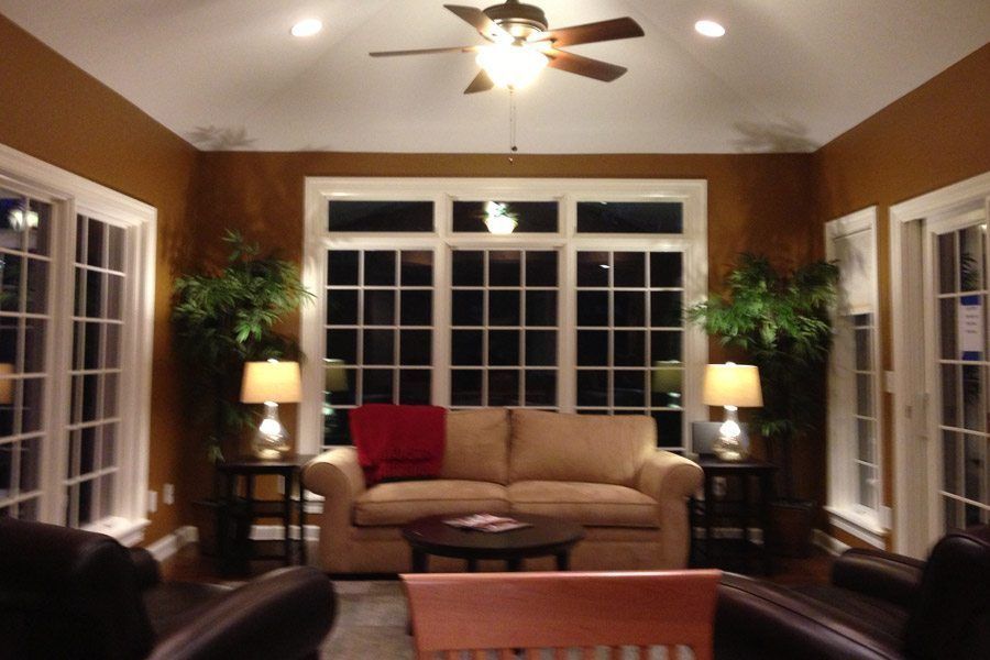 A living room with a couch and chairs and a ceiling fan