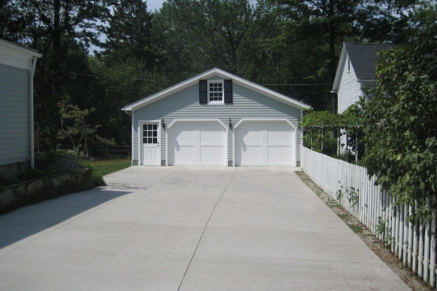 A white garage with a driveway leading to it