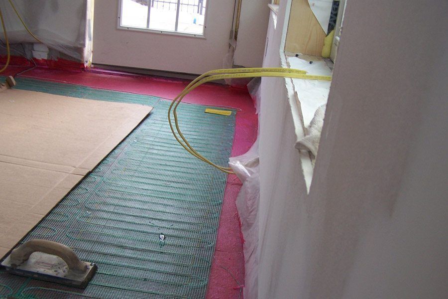 A room with a green and red rug and a tool on the floor.