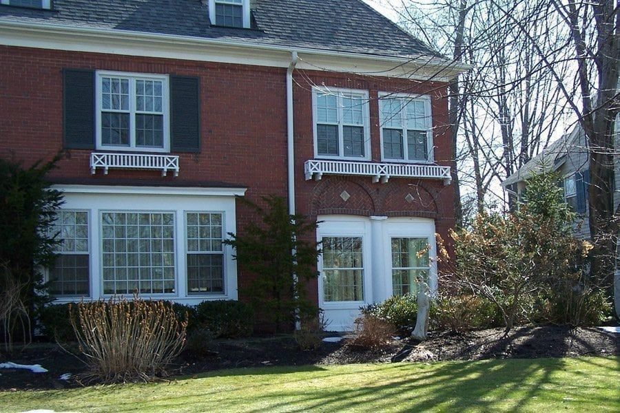 A red brick house with white trim and black shutters