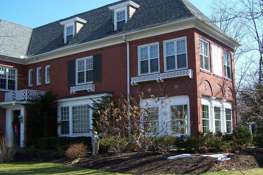 A large brick house with many windows and shutters