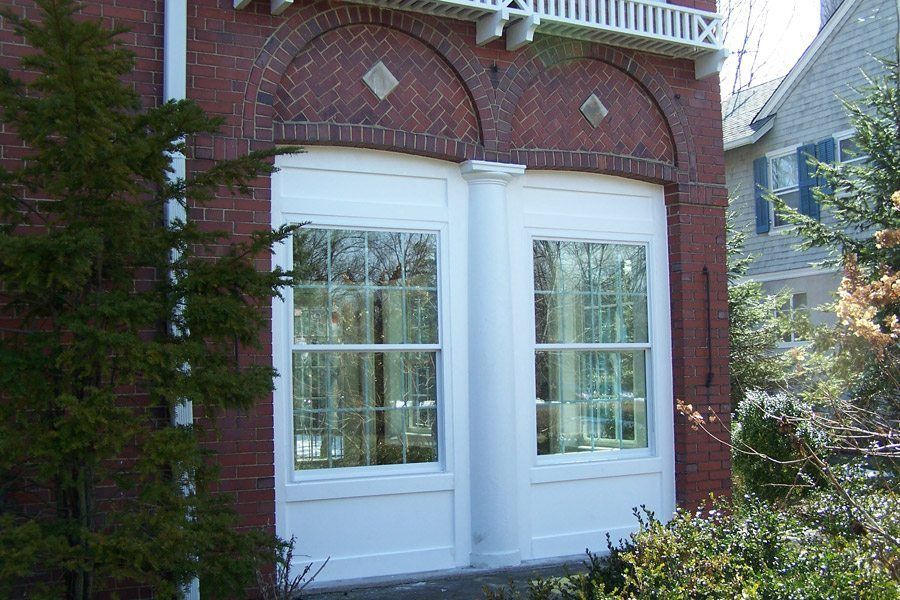 A brick building with white windows and a balcony