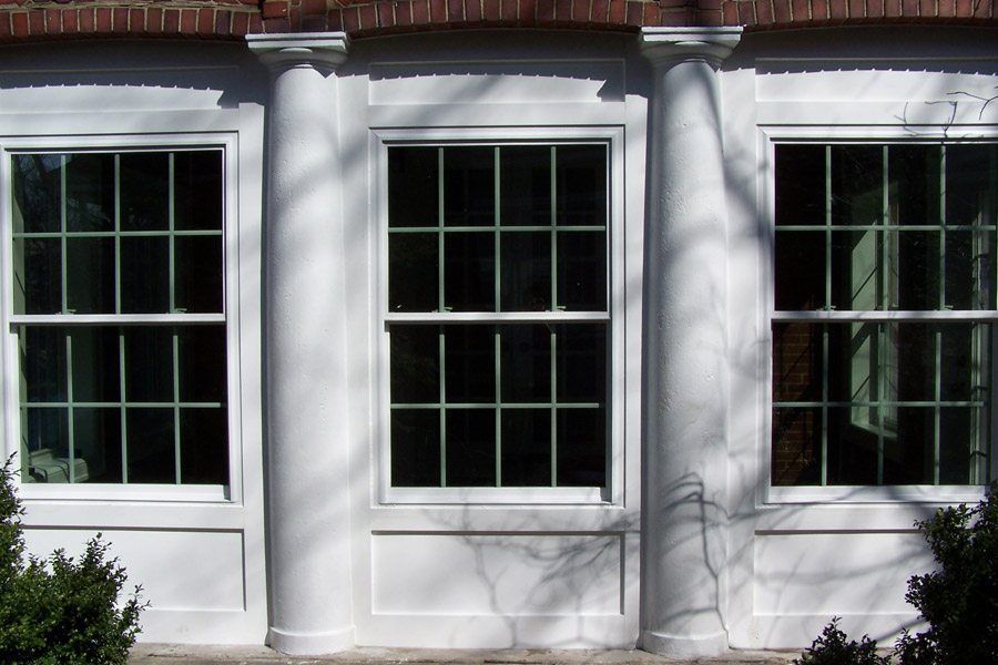 A row of white windows on a brick building