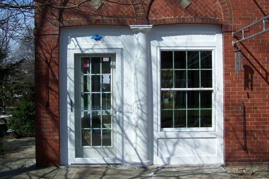 A brick building with a white door and window