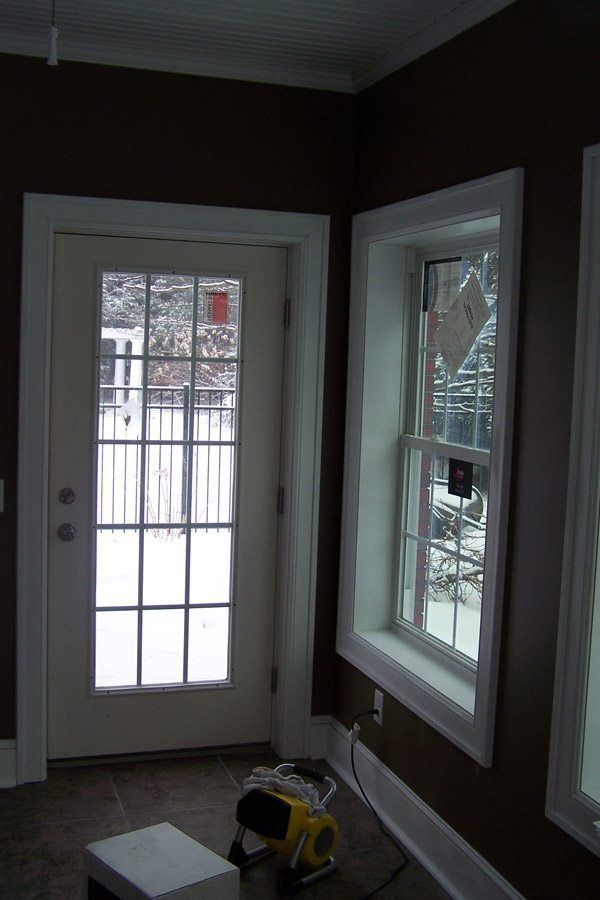 A room with a french door and two windows