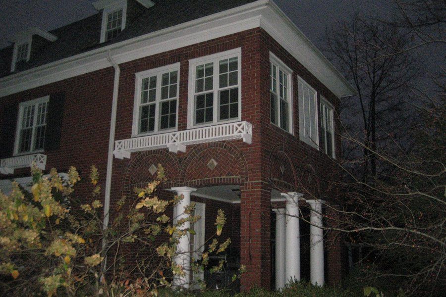 A large brick house with a porch at night