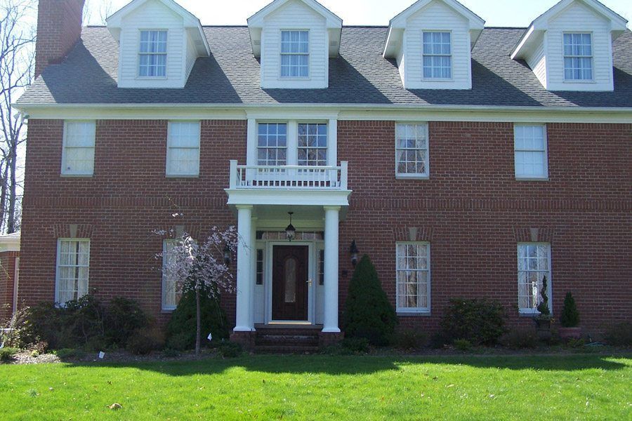 A large brick house with white trim and a black door