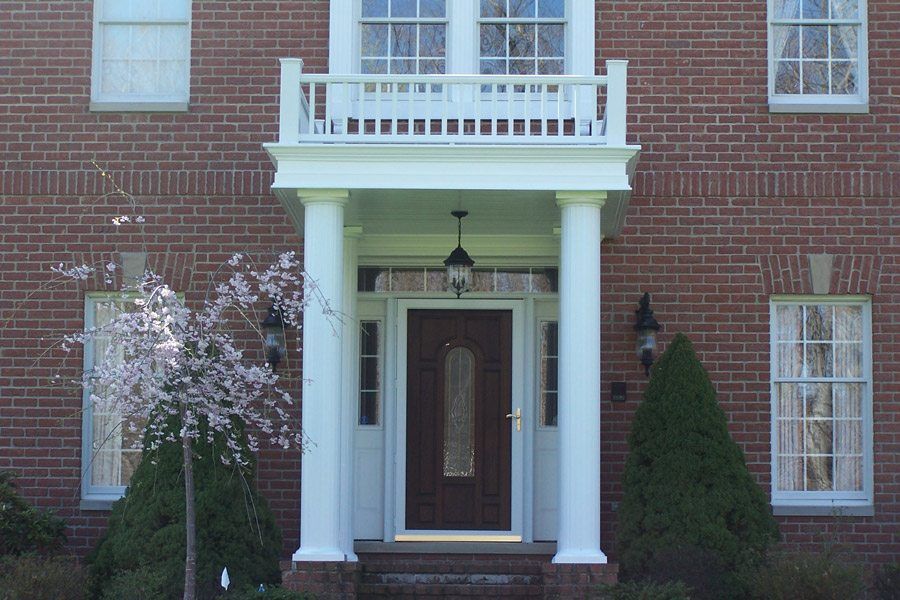 A brick house with a porch and a balcony