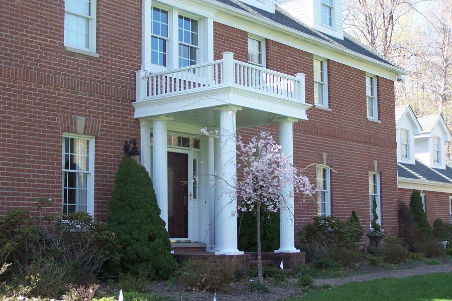 A large brick house with a porch and columns